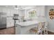 Bright kitchen featuring white cabinetry, stainless steel appliances, and a breakfast bar with seating at 626 Bailey Rd, Coats, NC 27521