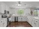 Bright kitchen featuring white cabinets, stainless steel appliances, and hardwood floors at 626 Bailey Rd, Coats, NC 27521