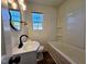 Bathroom featuring vanity, dark fixtures, updated lighting and mirror, toilet, and a tub at 710 Dothan Ave, Burlington, NC 27217