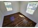 Bedroom with hardwood floors, white walls and trim, and two windows, providing natural light at 710 Dothan Ave, Burlington, NC 27217