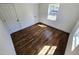 Bedroom with hardwood floors, white walls and trim, and one window, showcasing a clean and inviting space at 710 Dothan Ave, Burlington, NC 27217
