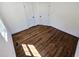 Bedroom featuring hardwood floors, white walls, baseboards, and two white doors at 710 Dothan Ave, Burlington, NC 27217