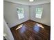 Bright bedroom featuring hardwood floors, natural light from two windows, and fresh white walls at 710 Dothan Ave, Burlington, NC 27217