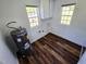 Clean laundry room featuring wood-look flooring, cabinets, and two bright windows at 710 Dothan Ave, Burlington, NC 27217