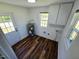 Bright laundry room with wood-look flooring, cabinets, and an exterior door at 710 Dothan Ave, Burlington, NC 27217