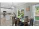 Cozy dining area with modern light fixtures, a table set for four, and view to backyard at 712 Wellspring Dr, Holly Springs, NC 27540