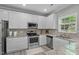 The kitchen features stainless steel appliances and white cabinetry at 712 Wellspring Dr, Holly Springs, NC 27540