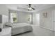 Comfortable main bedroom with tray ceiling, fan, and natural light coming through two windows at 712 Wellspring Dr, Holly Springs, NC 27540