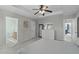 Bright main bedroom with gray walls, ensuite bathroom, tray ceiling, and a mirrored dresser at 712 Wellspring Dr, Holly Springs, NC 27540
