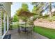 Outdoor patio with dining set and umbrella, bordered by lush landscaping and a white picket fence at 712 Wellspring Dr, Holly Springs, NC 27540