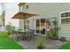 Outdoor patio featuring dining set, umbrella, greenery, and convenient access to the house at 712 Wellspring Dr, Holly Springs, NC 27540