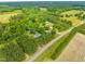 Aerial view of a tree covered lot with multiple dwellings and outbuildings at 7129 Dexter Rd, Oxford, NC 27565