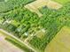 An aerial view shows a house in a large tract of wooded and farmed land at 7129 Dexter Rd, Oxford, NC 27565