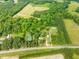 Aerial view of property with lush green forest surrounding multiple houses and buildings at 7129 Dexter Rd, Oxford, NC 27565