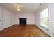 A bedroom with a fireplace, two closets, pink walls, white trim and wood floor at 7129 Dexter Rd, Oxford, NC 27565