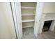 Hallway closet with shelving and ceramic tile floor, next to a fireplace at 7129 Dexter Rd, Oxford, NC 27565