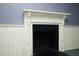 A close up view of a fireplace with white painted trim, and black painted surround at 7129 Dexter Rd, Oxford, NC 27565