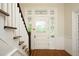 Staircase next to a door with decorative glass panels and classic trim, showcasing the home's elegance at 7129 Dexter Rd, Oxford, NC 27565