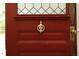 Close-up of a red front door featuring a detailed knocker and hardware, adding a touch of elegance at 7129 Dexter Rd, Oxford, NC 27565