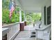 Relaxing front porch showcasing an American flag and white wicker chairs, perfect for enjoying the outdoors at 7129 Dexter Rd, Oxford, NC 27565