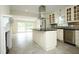 Bright kitchen with island, stainless appliances, tile flooring, and connected seating area at 7129 Dexter Rd, Oxford, NC 27565