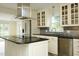 Kitchen with island, stainless steel appliances, stone backsplash, and glass front cabinets at 7129 Dexter Rd, Oxford, NC 27565