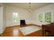 Traditional living room with hardwood floors, fireplace, wainscoting, and bright windows at 7129 Dexter Rd, Oxford, NC 27565