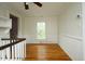 Bright loft featuring wood floors, a window, and white walls with wood paneling at 7129 Dexter Rd, Oxford, NC 27565