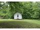 Quaint white outbuilding surrounded by lush greenery, suitable for a studio or hobby space at 7129 Dexter Rd, Oxford, NC 27565