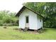 Exterior view of a small white outbuilding with a door, ideal for storage or a personal retreat at 7129 Dexter Rd, Oxford, NC 27565