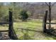 Rustic gate and fence leading to a beautiful wooded area, creating a tranquil and inviting entrance at 7129 Dexter Rd, Oxford, NC 27565