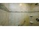 Close-up of the shower with tiled walls, built-in shelves, and a grab bar at 7129 Dexter Rd, Oxford, NC 27565