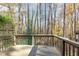 A wooden back deck overlooks an enchanting wooded area with changing fall colors and plenty of lush, green foliage at 7324 Summerland Dr, Raleigh, NC 27612