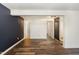 Open basement with vinyl flooring, dark accent wall, and multiple doorways at 7324 Summerland Dr, Raleigh, NC 27612