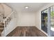 Bright living room featuring vinyl flooring, modern staircase, and sliding door access to the deck at 7324 Summerland Dr, Raleigh, NC 27612