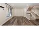 Well-lit living room featuring hardwood floors, stairs to the second floor, and a large window at 7324 Summerland Dr, Raleigh, NC 27612