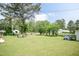Expansive backyard featuring a well-manicured lawn, a cozy firepit area, mature trees, and ample space for outdoor activities at 7698 Nc Highway 222, Kenly, NC 27542