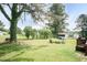 Lush backyard with mature trees, a cozy fire pit area, and plenty of space for relaxation and outdoor gatherings at 7698 Nc Highway 222, Kenly, NC 27542