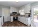 Bright kitchen featuring white cabinetry, granite countertops, stainless steel appliances, and wood-look flooring at 7698 Nc Highway 222, Kenly, NC 27542