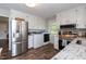 Modern kitchen features stainless steel appliances, white cabinets, granite countertops, and convenient laundry area at 7698 Nc Highway 222, Kenly, NC 27542