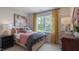Bedroom boasts a large window, decorative pillows and artwork, and wood furniture at 770 Dorset Stream Dr, Fuquay Varina, NC 27526