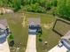 Aerial view of a home with a well-manicured lawn and mature trees in a suburban setting at 80 Doonbeg Dr, Fuquay Varina, NC 27526