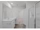 This bathroom features a full-sized mirror, shower, sleek vanity with chrome pulls and wood flooring at 80 Doonbeg Dr, Fuquay Varina, NC 27526