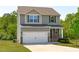 Two-story home features a two-car garage, neutral siding, and a well-maintained front yard at 80 Doonbeg Dr, Fuquay Varina, NC 27526