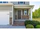 Inviting front porch with stone accents, brick steps, and decorative shrubs at 80 Doonbeg Dr, Fuquay Varina, NC 27526