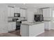 This kitchen features white cabinets, black appliances, granite countertops, and a large island at 80 Doonbeg Dr, Fuquay Varina, NC 27526