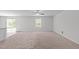 Spacious carpeted living room with abundant natural light and modern ceiling fan at 80 Doonbeg Dr, Fuquay Varina, NC 27526