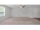 Neutral carpeted living room with overhead ceiling fan and large windows for natural light at 80 Doonbeg Dr, Fuquay Varina, NC 27526