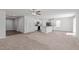 Open-concept living space features carpeted living room and white kitchen with black appliances at 80 Doonbeg Dr, Fuquay Varina, NC 27526