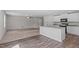 Open-concept living space features carpeted living room and kitchen with black appliances at 80 Doonbeg Dr, Fuquay Varina, NC 27526